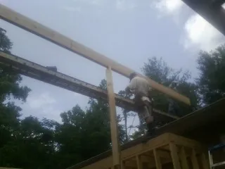 Carpenter setting a ridge beam over a new addition frame — Ice Dam Removal by Roofing Brothers in Goldens Bridge