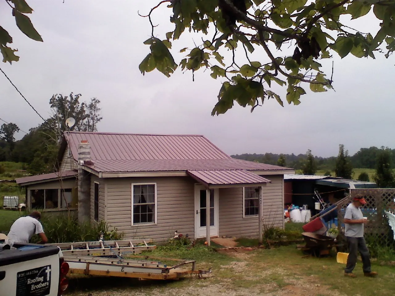 Crew finishing a mauve metal roof on a small farmhouse in Goldens Bridge