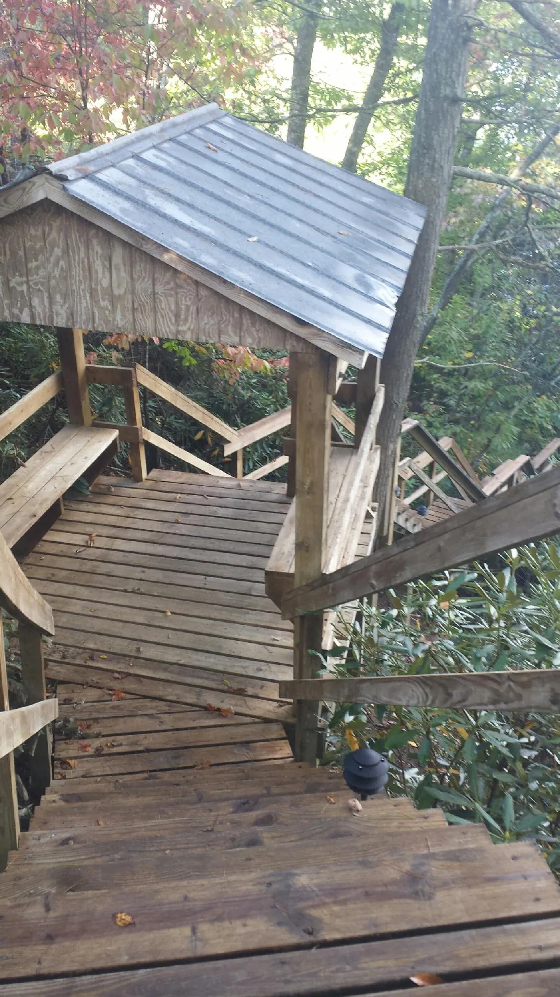 Metal roofed shelter over wooden steps on a wooded walkway — Skylight Repair & Installation work by our crew in Goldens Bridge